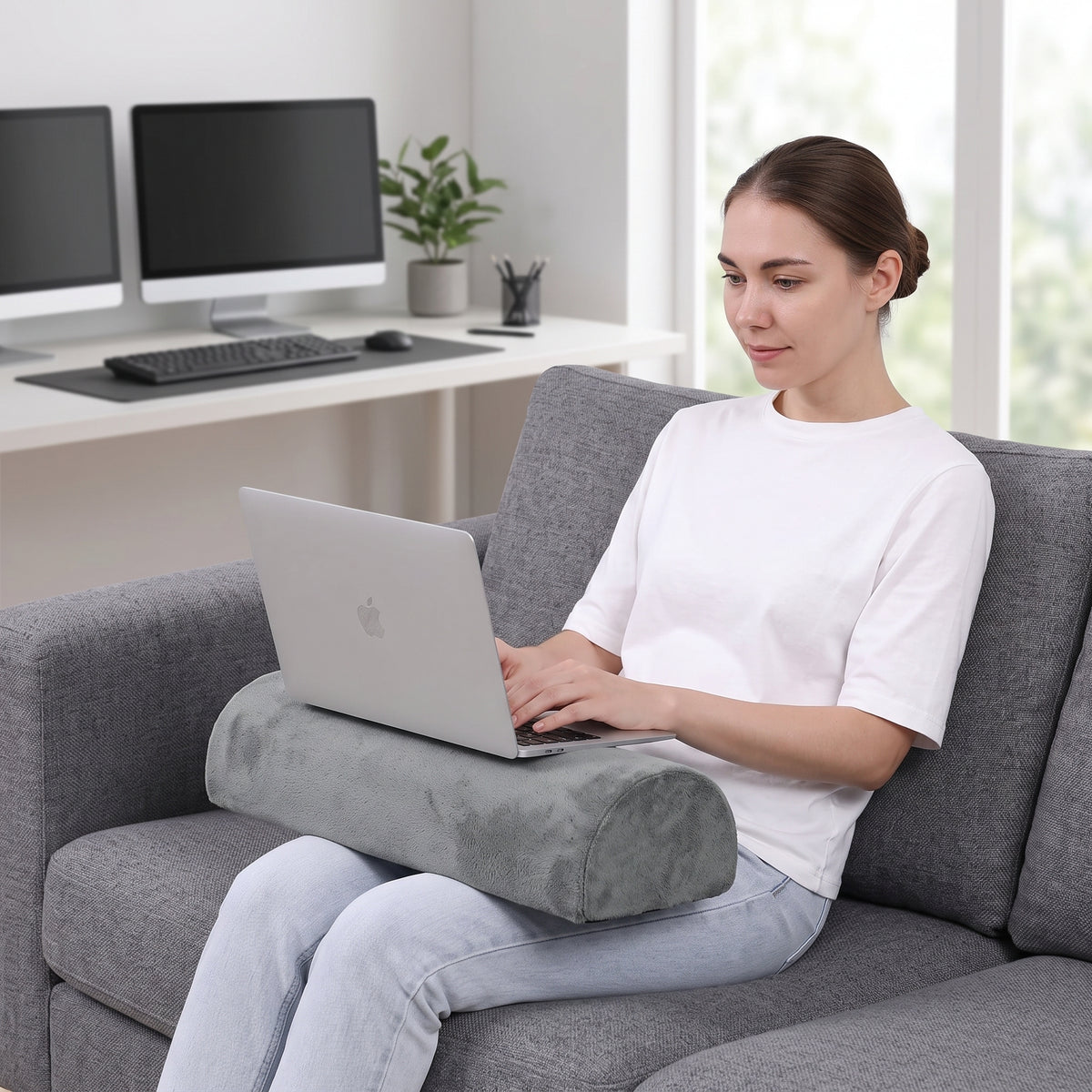 Coussin demi-rouleau utilisé comme support d'ordinateur portable, assise sur un canapé
