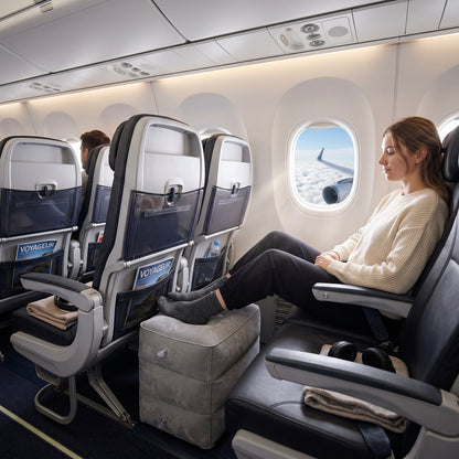 Repose-pieds gonflable installé au sol devant un siège d'avion